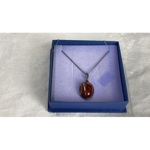 127 - Sterling silver necklace featuring an amber gemstone pendant. Marked 