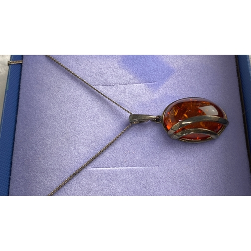 127 - Sterling silver necklace featuring an amber gemstone pendant. Marked 