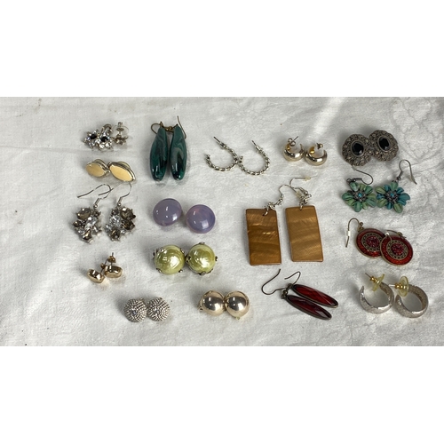 129 - Collection of diverse earrings featuring various gemstones, enamel, and metal designs. Styles includ... 