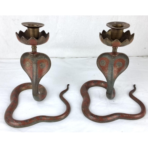 29 - Pair of brass cobra candlesticks with detailed etched designs and curled snake bases in red-toned me... 