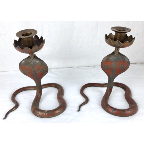 29 - Pair of brass cobra candlesticks with detailed etched designs and curled snake bases in red-toned me... 