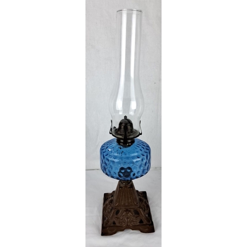 30 - Antique blue glass oil lamp with a textured surface, featuring an ornate cast iron base. Victorian s... 