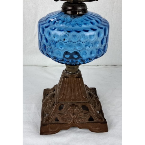 30 - Antique blue glass oil lamp with a textured surface, featuring an ornate cast iron base. Victorian s... 