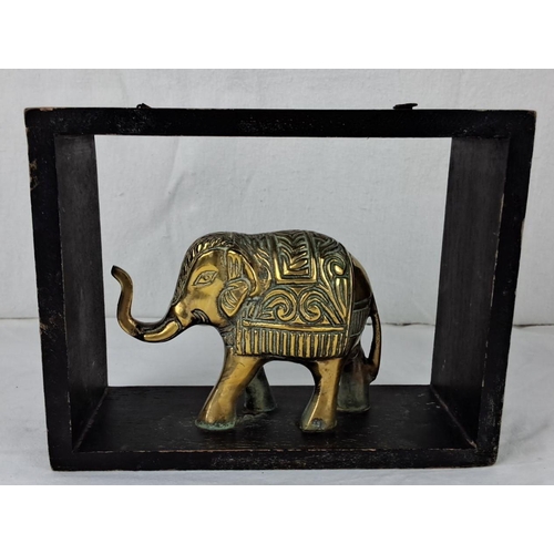 44 - Brass elephant figurine in carved display frame. It features intricate detailing on the elephant wit... 