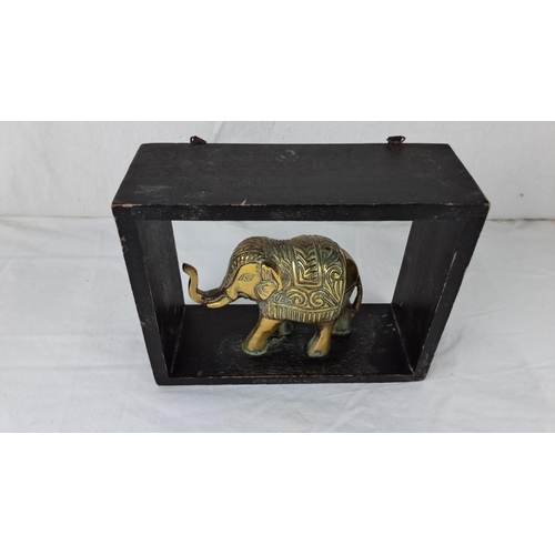 44 - Brass elephant figurine in carved display frame. It features intricate detailing on the elephant wit... 