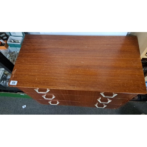 69 - Mid-Century Modern teak veneer chest of drawers with tapered legs and metal handles.