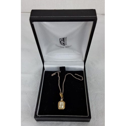 87 - Sterling silver necklace features a gold plated-accented pendant with a central pearl and small gems... 