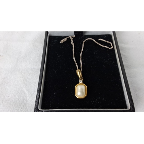 87 - Sterling silver necklace features a gold plated-accented pendant with a central pearl and small gems... 