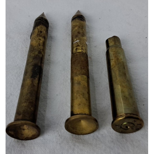 91 - Three vintage brass projectile casings, tapered design with pointed ends.