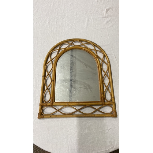 441 - Rattan wall mirror features an intricate woven pattern and arch-shaped design.