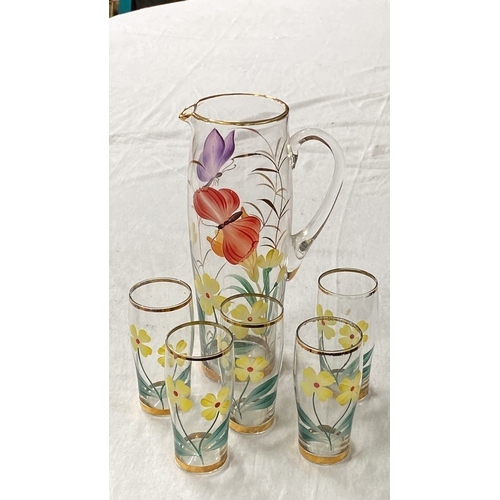 448 - Hand-painted glass pitcher and tumblers set, featuring vibrant floral and butterfly motifs with gold... 