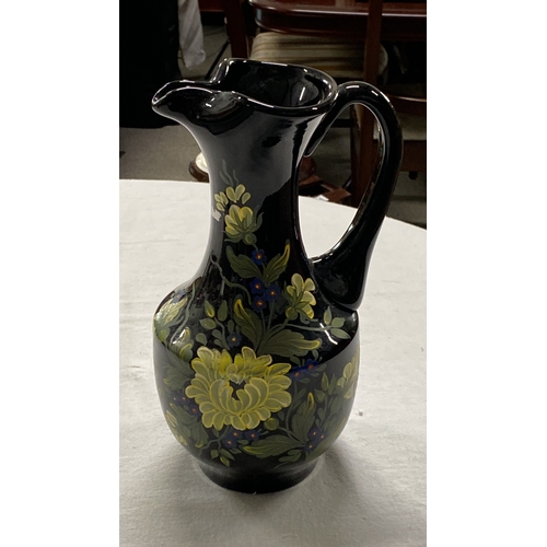 455 - Hand-painted glass pitcher with floral motif. Features vibrant yellow and blue flowers on a glossy b... 