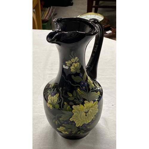 455 - Hand-painted glass pitcher with floral motif. Features vibrant yellow and blue flowers on a glossy b... 