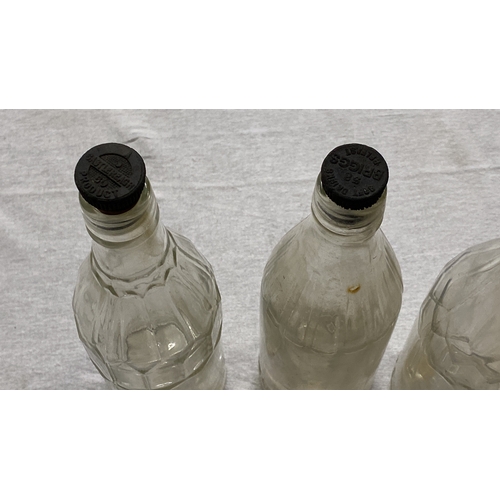 457 - Set of three vintage glass bottles with molded details and original black caps. Marked 