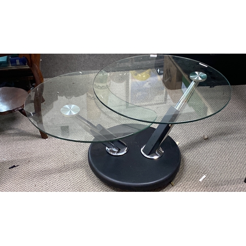 477 - Modern glass coffee table with a dual-tier design and chrome supports, featuring a round black base ... 