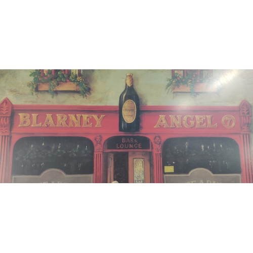 452 - Large Framed print of the Blarney Angel pub, featuring a vibrant street scene. Set in a wooden frame... 