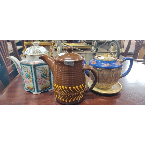 473 - Trio of teapots including a brown ceramic piece with yellow detail, a cobalt blue floral teapot with... 