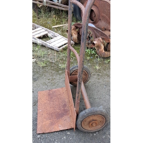 1 - Vintage metal hand truck with two wheels and a wide loading base. Features a rustic, aged patina.