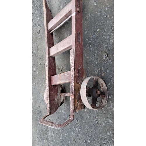 17 - Antique wooden hand truck with metal wheels, showcasing rustic charm, from the early 20th century.