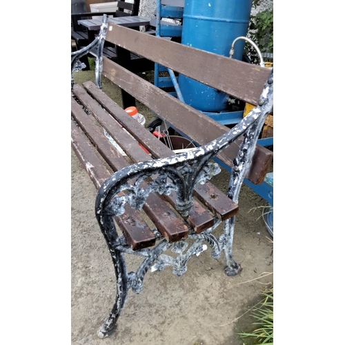 23 - Ornate Victorian-style cast aluminium garden bench with brown wooden slats, featuring intricate scro... 