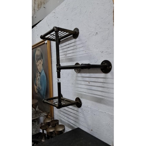 75 - Metal wall shelf with three tiers, featuring a pipe design and horizontal bar racks.