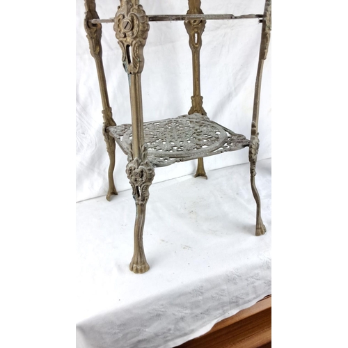 85 - Victorian style cast iron plant stand with intricate scrollwork and three-tiered design features orn... 