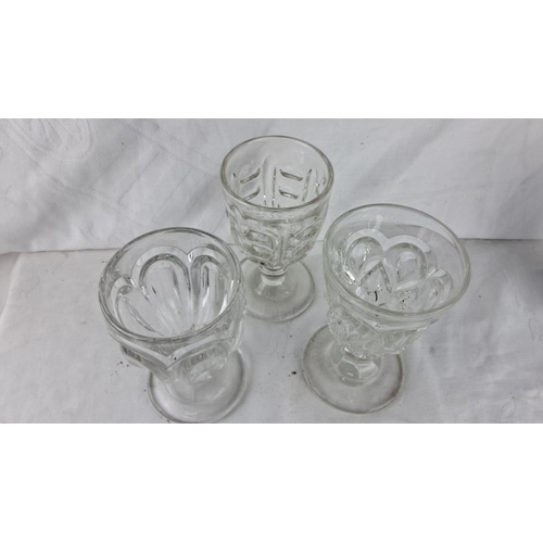 86 - Set of three vintage pressed glass goblets with intricate pattern detailing.