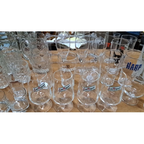 94 - Collection of branded glassware including Guinness, Harp, San Miguel, and Hennessy. Various sizes an... 