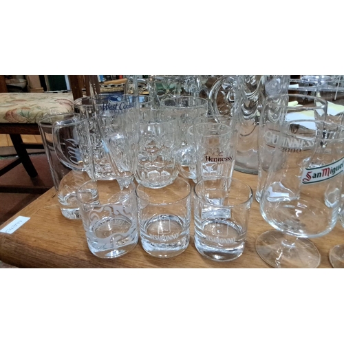 94 - Collection of branded glassware including Guinness, Harp, San Miguel, and Hennessy. Various sizes an... 