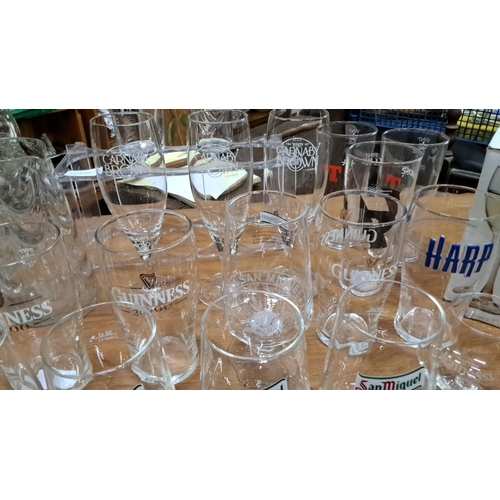 94 - Collection of branded glassware including Guinness, Harp, San Miguel, and Hennessy. Various sizes an... 