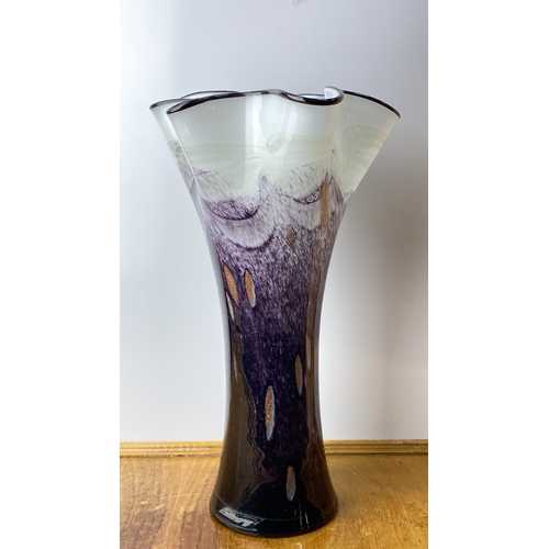 200 - Hand-blown glass vase features elegant purple and white swirl patterns with a fluted rim. Measuring ... 