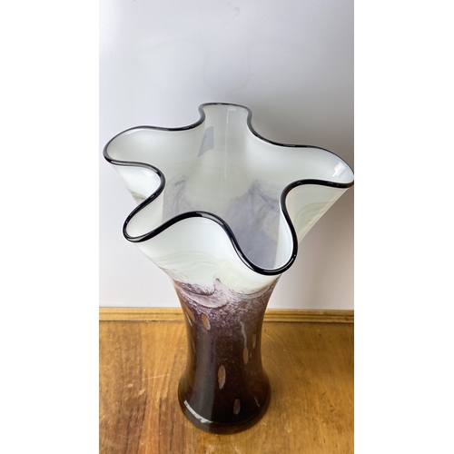 200 - Hand-blown glass vase features elegant purple and white swirl patterns with a fluted rim. Measuring ... 