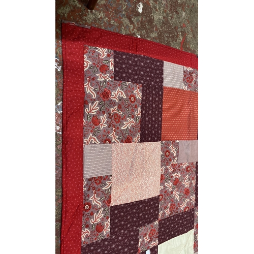 217 - Patchwork quilt features floral and geometric patterns in red and burgundy tones. Reversible with so... 