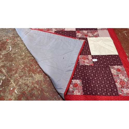 217 - Patchwork quilt features floral and geometric patterns in red and burgundy tones. Reversible with so... 