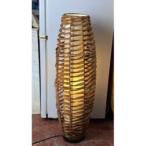 221 - Contemporary wicker floor lamp with woven design and inner light diffuser.