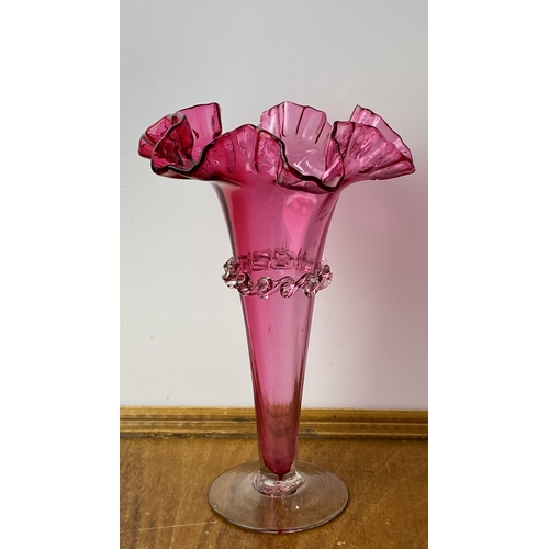 226 - Antique Ruby  glass vase featuring a ruffled edge and applied clear glass decoration.