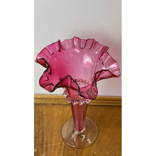 226 - Antique Ruby  glass vase featuring a ruffled edge and applied clear glass decoration.