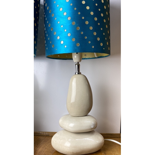 229 - Pair of modern table lamps with cream stone-like bases and vibrant blue shades featuring gold polka ... 