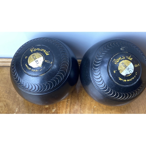 231 - Pair of vintage lawn bowls featuring 