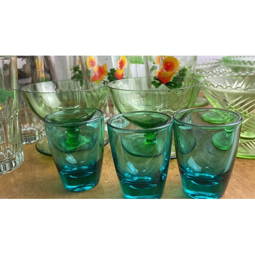 240 - Collection of vintage glassware features a floral-etched water pitcher, matching tumblers, green gla... 