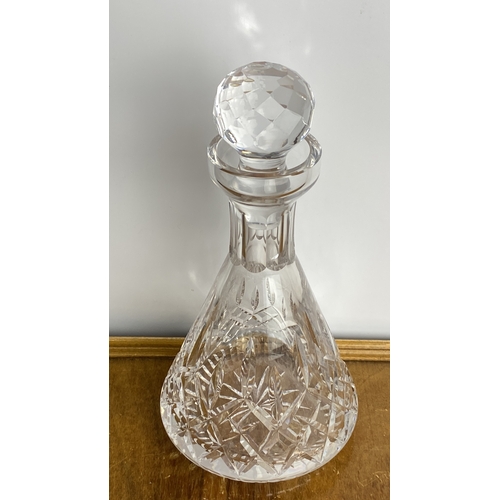 251 - Cut glass decanter features a diamond cut pattern with a faceted stopper.