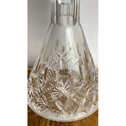 251 - Cut glass decanter features a diamond cut pattern with a faceted stopper.