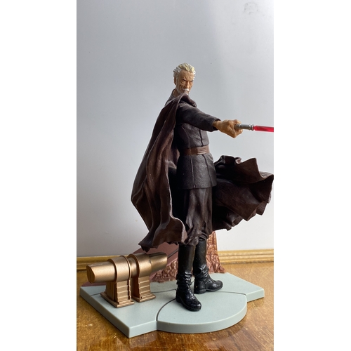 282 - Collectible action figure, depicting a character with a red lightsaber, mounted on a base.