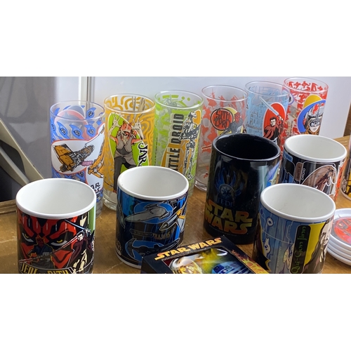 283 - Collection of Star Wars themed mugs and glasses, featuring various characters and designs, alongside... 