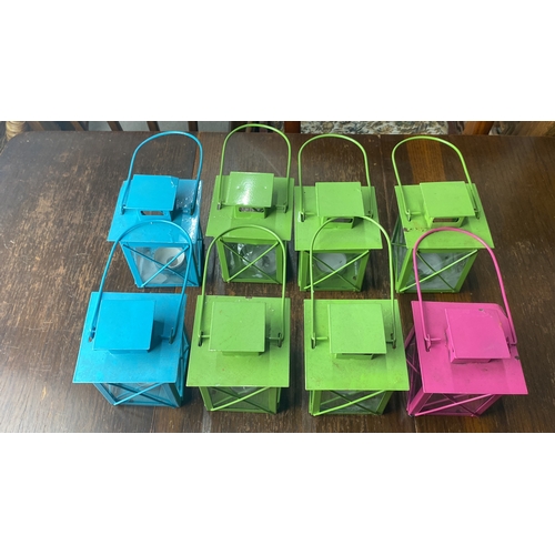 303 - Set of eight vibrant metal lanterns in blue, green, and pink. Each features glass panels and metal c... 