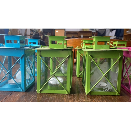 303 - Set of eight vibrant metal lanterns in blue, green, and pink. Each features glass panels and metal c... 