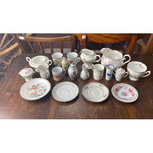 307 - Porcelain tea set with floral patterns includes cups, saucers, creamers, and sugar bowls. Various st... 