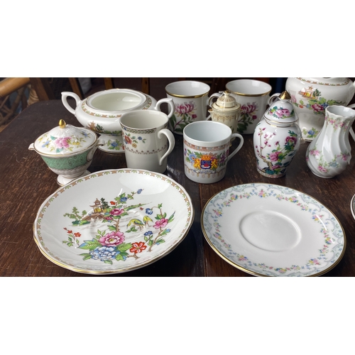 307 - Porcelain tea set with floral patterns includes cups, saucers, creamers, and sugar bowls. Various st... 