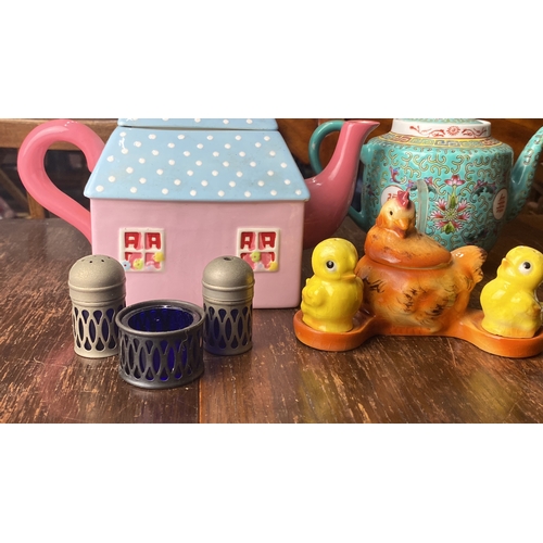 329 - Collection of decorative teapots, salt shakers, and figurines. Includes a house-shaped pastel teapot... 