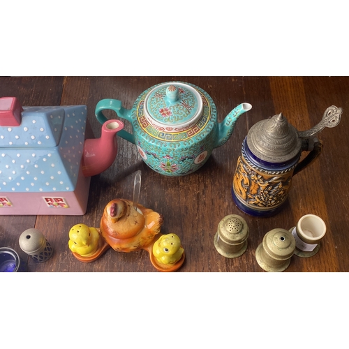 329 - Collection of decorative teapots, salt shakers, and figurines. Includes a house-shaped pastel teapot... 